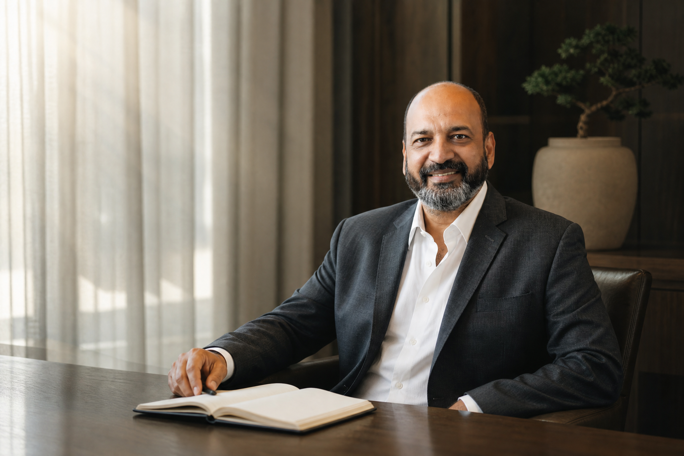 Sanjiv Agarwal seated at a writing desk in a contemporary study